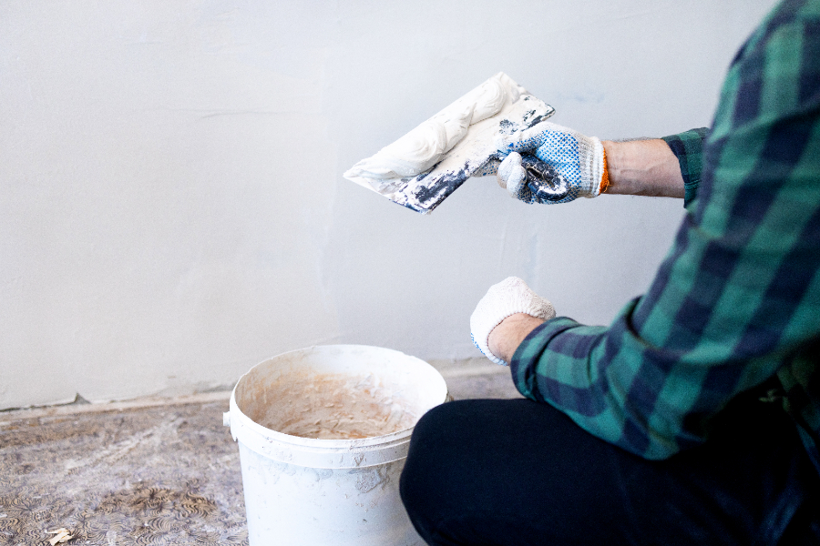 Un homme qui utilise du map pour enduire ses murs