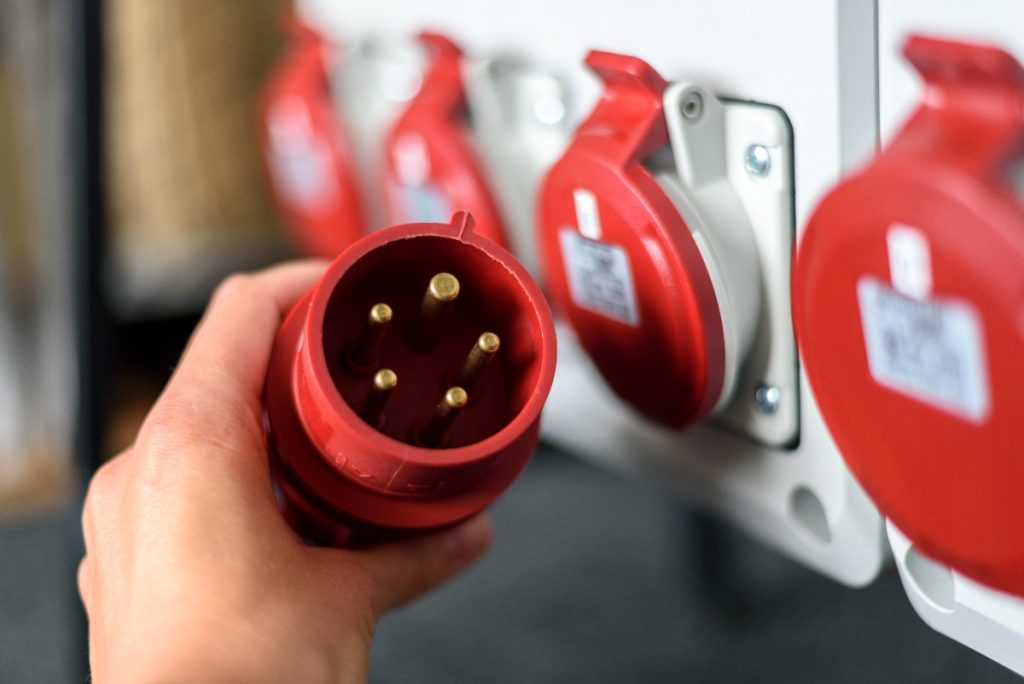 Un multimètre posé sur volts contrôle la tension entre deux broches d’une prise remorque 7 broches