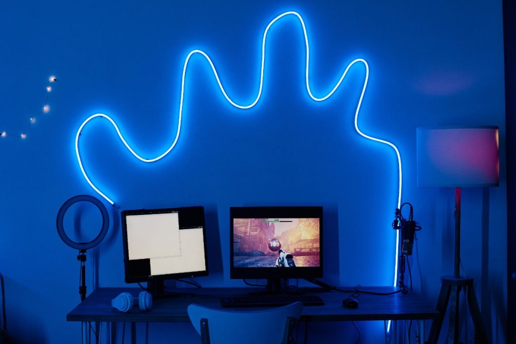 Des néons LED branchés dans une chambre avec des ordinateurs sur une table