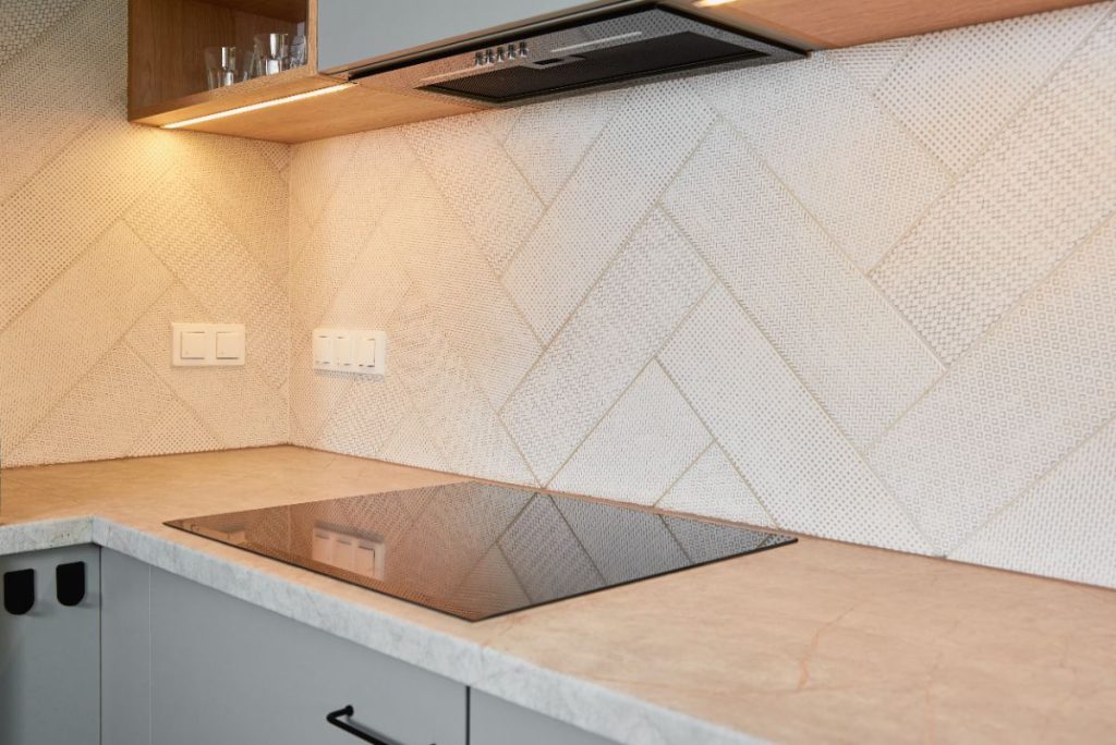 Une plaque induction installée à côté des prises normales dans une cuisine