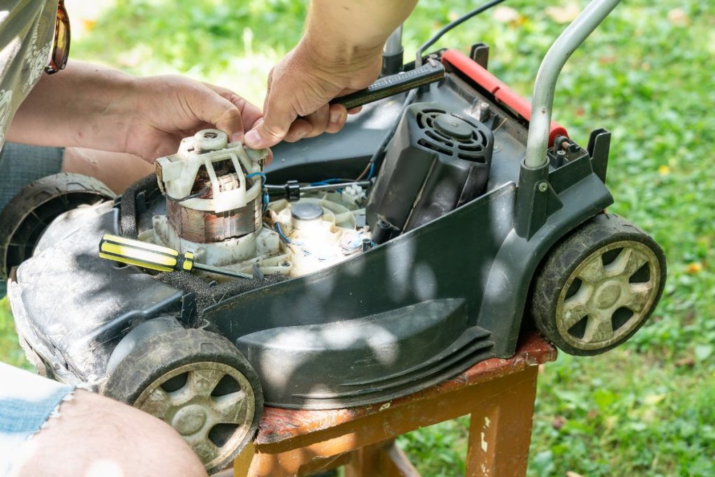 Un homme ajustant le ressort sur le Briggs Stratton