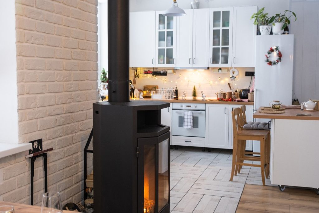 Une cheminée installée dans la maison, avec un filtre sur la grille