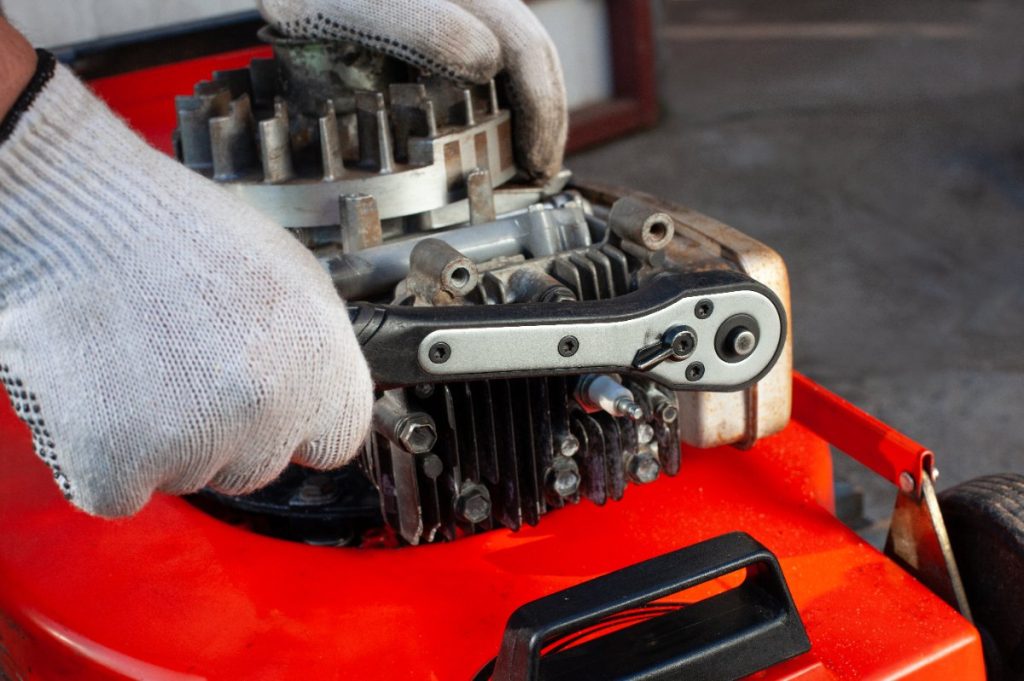Une personne faisant un réglage du moteur et du ressort sur le Briggs Stratton