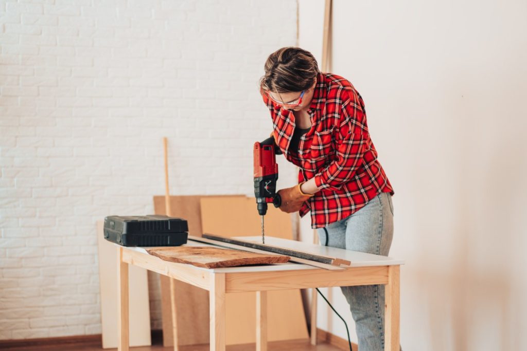 Un homme qui assemble deux plans travail pour faire une table