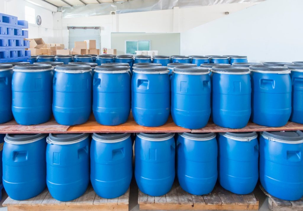 Des barils en plastiques de couleur bleu stockés dans une usine