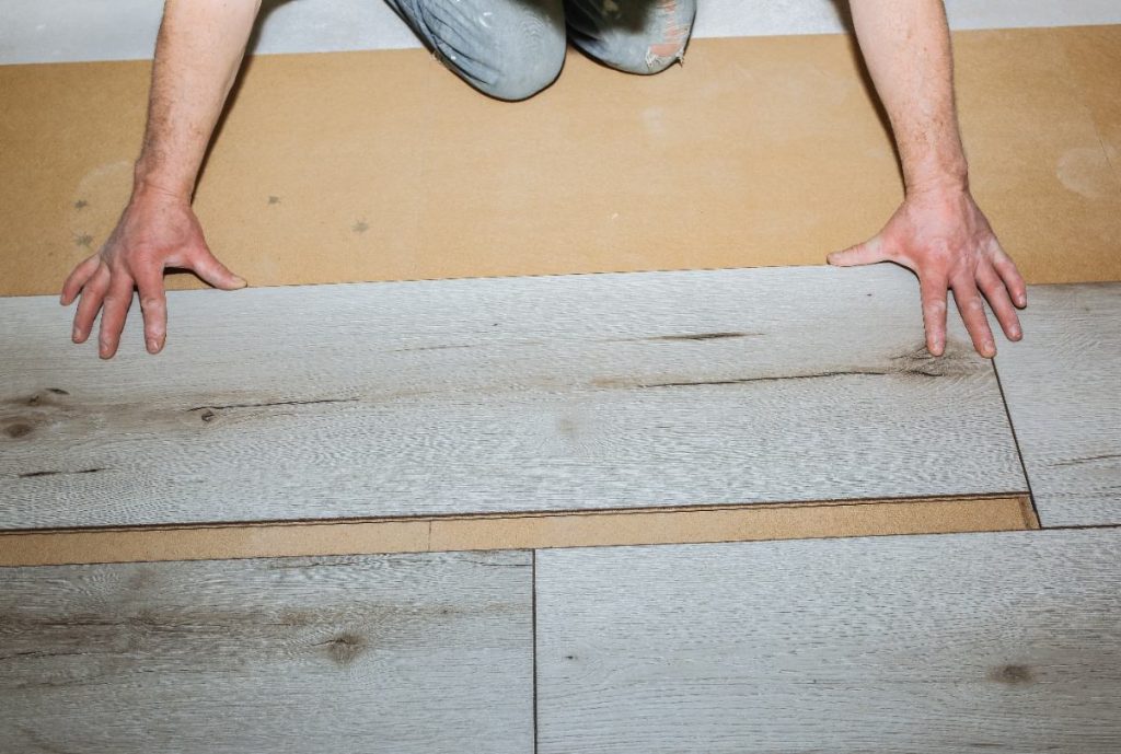 Un ouvrier qui installe du plancher stratifié