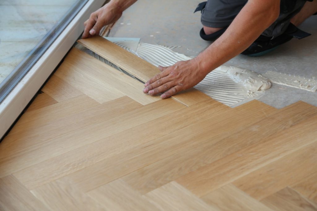 Peut-on installer du parquet flottant directement sur un ancien revêtement lino ? Une personne qui installe du plancher en bois