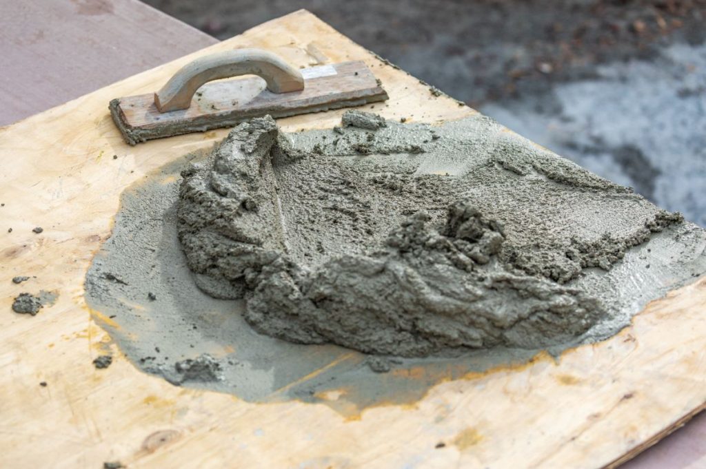 Du mortier frais avec une truelle sur une plancher en bois