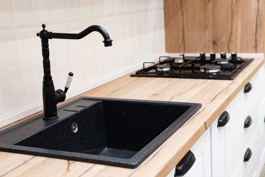 Un évier noir et une plaque de cuisson moderne