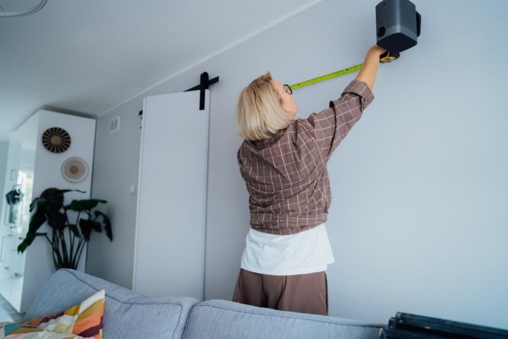 Une femme mesurant le mur