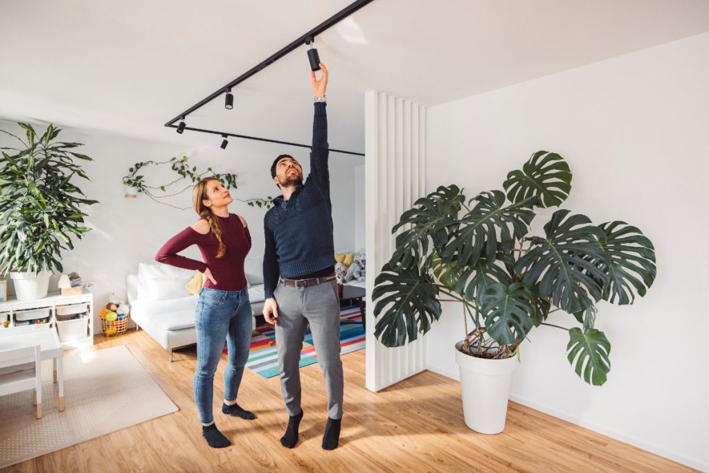 Un homme ajustant la lumière dans le salon