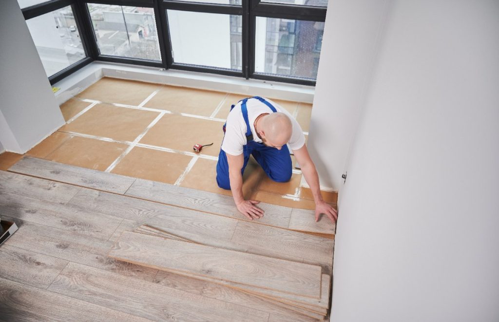 Un homme qui installe de nouveau parquet