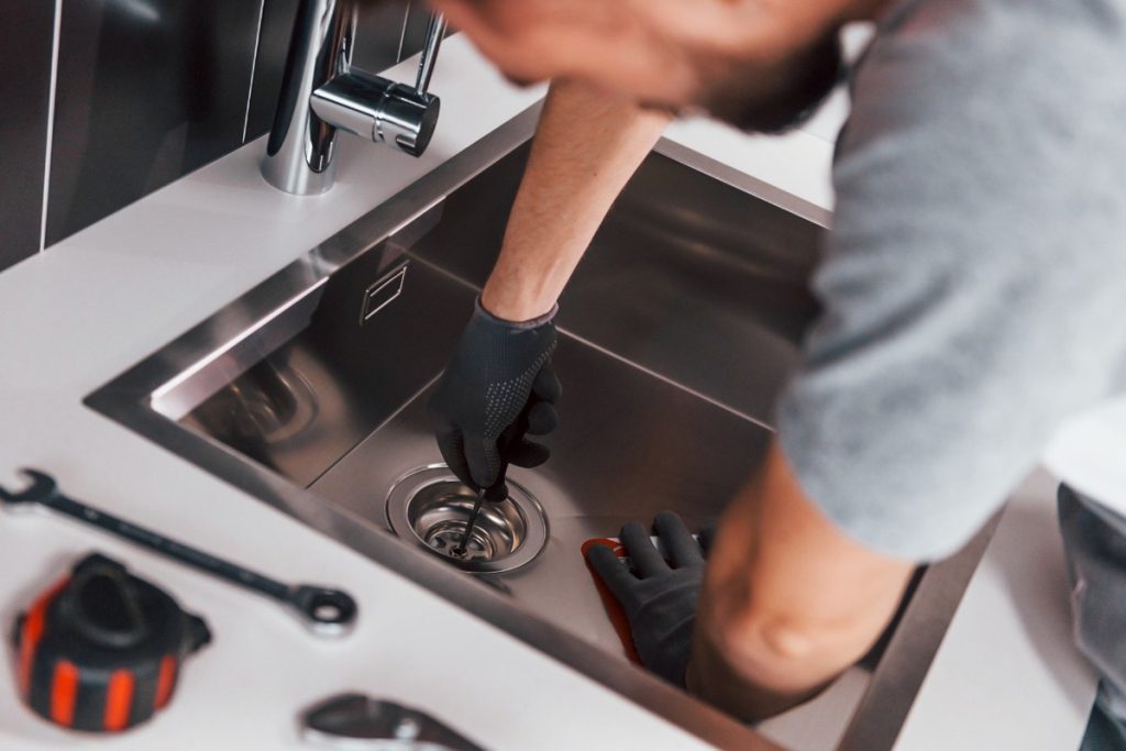 Un homme travaillant à réparer l'évier