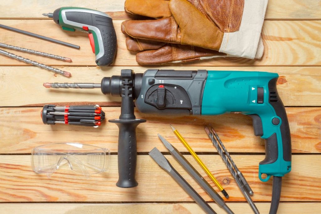 Une perceuse avec des autres outils sur une surface en bois