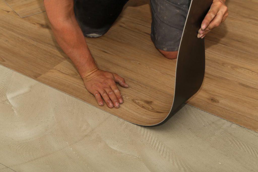 Une personne posant du lino sur le parquet